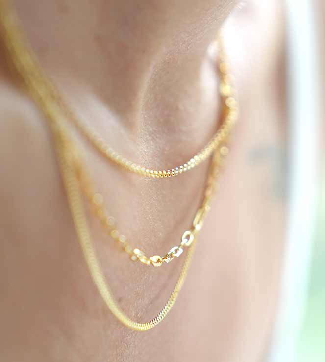 Woman wearing layered gold necklaces by WJD Exclusives