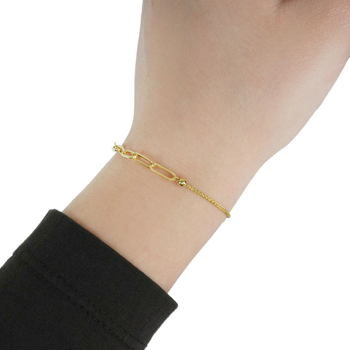 Gold bracelet on a wrist with a plain background [lifestyle]