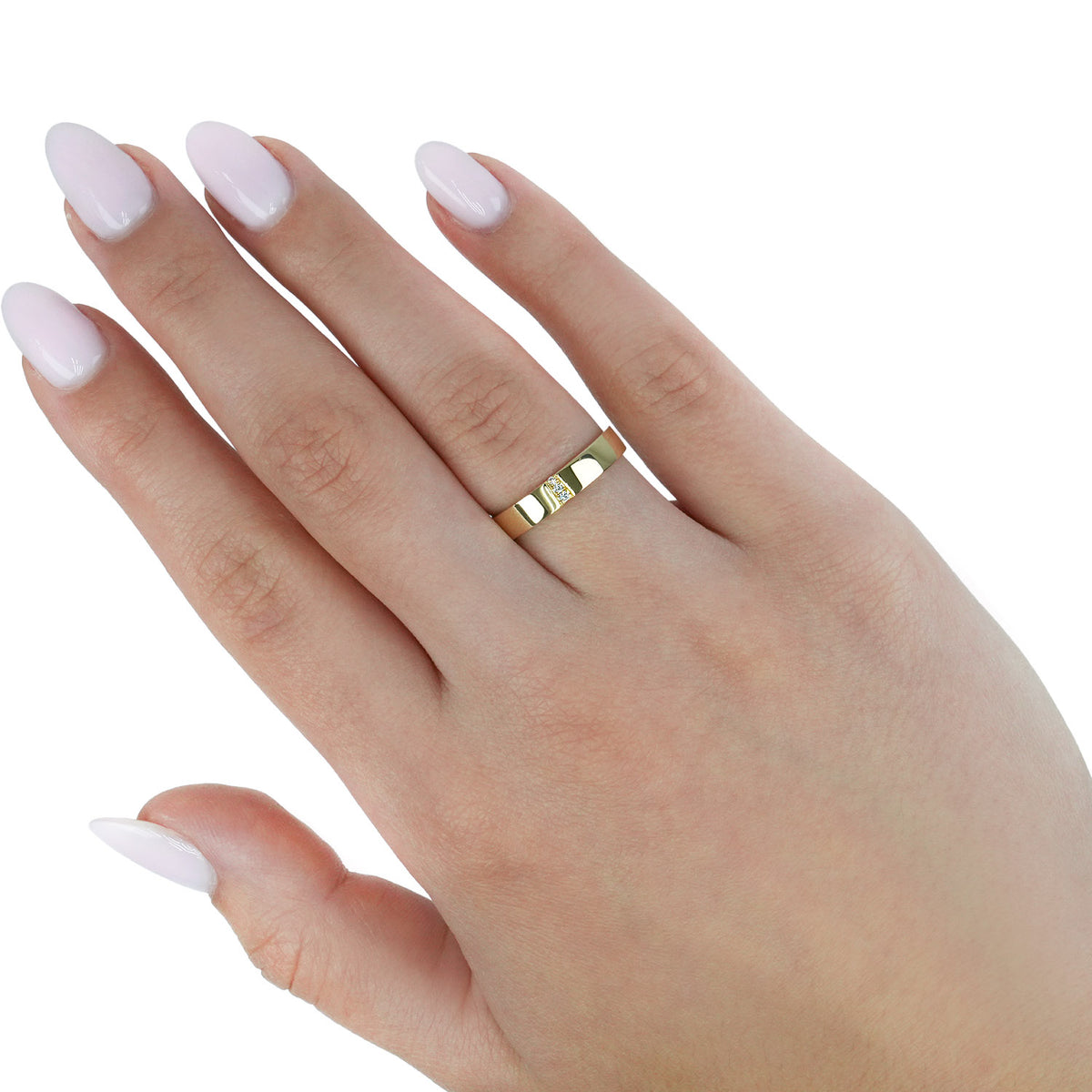 A close-up of a hand with pale pink manicured nails wearing a slim gold band ring with a small central clear gemstone, set against a plain white background. [lifestyle]