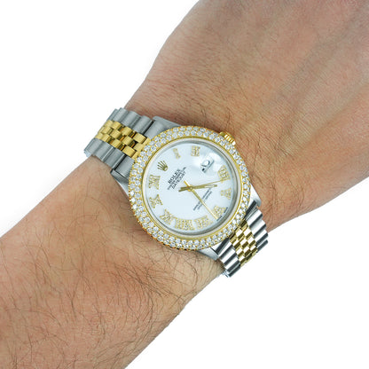 Gold and silver watch with diamond-studded bezel on a wrist against a white background [lifestyle]