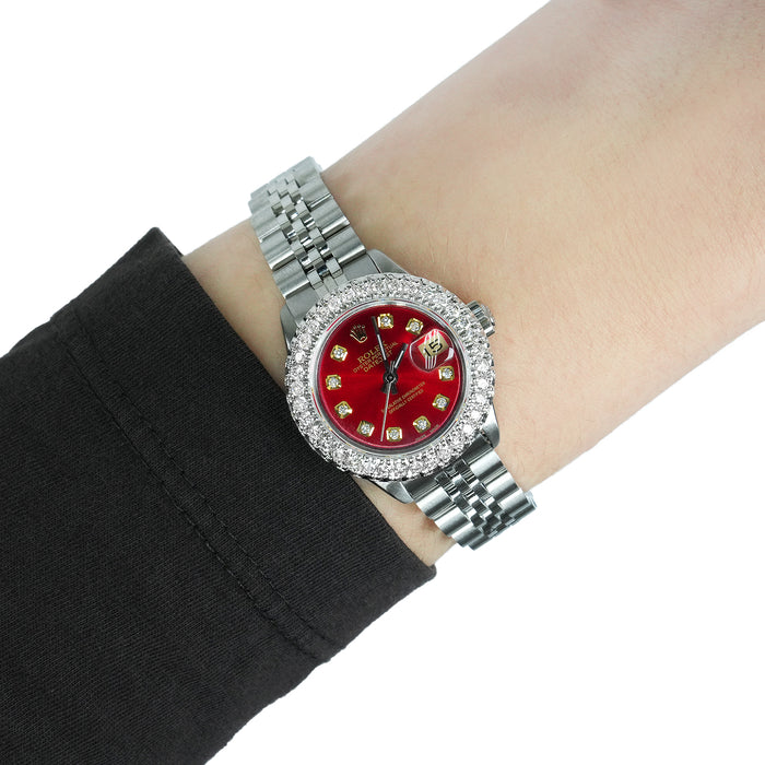 Silver watch with a red face and diamond accents on a wrist against a white background [lifestyle]