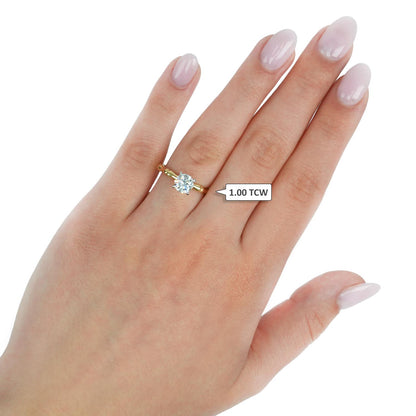 Gold ring with a diamond on a hand against a white background