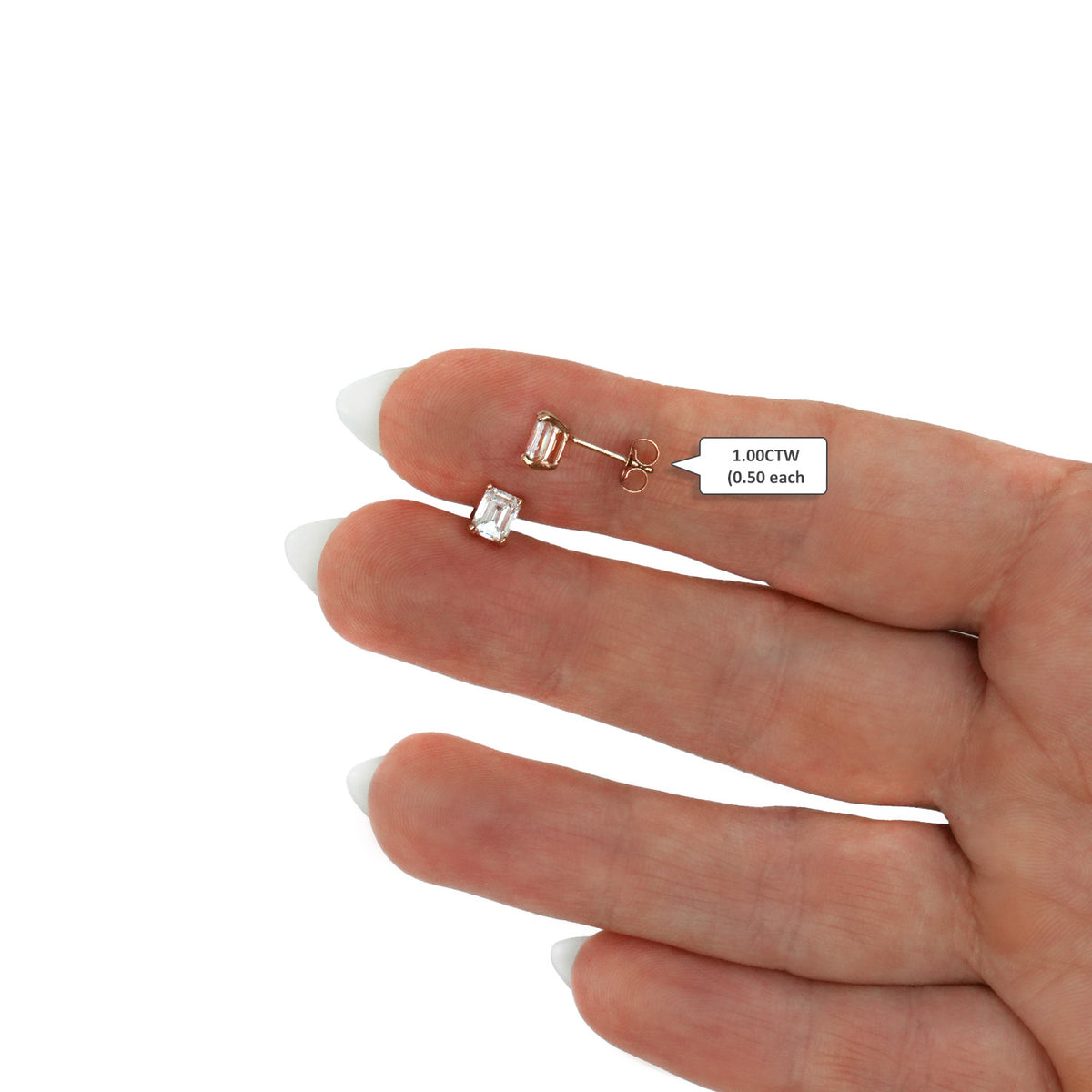 A close-up of a hand displaying a pair of small stud earrings [lifestyle]