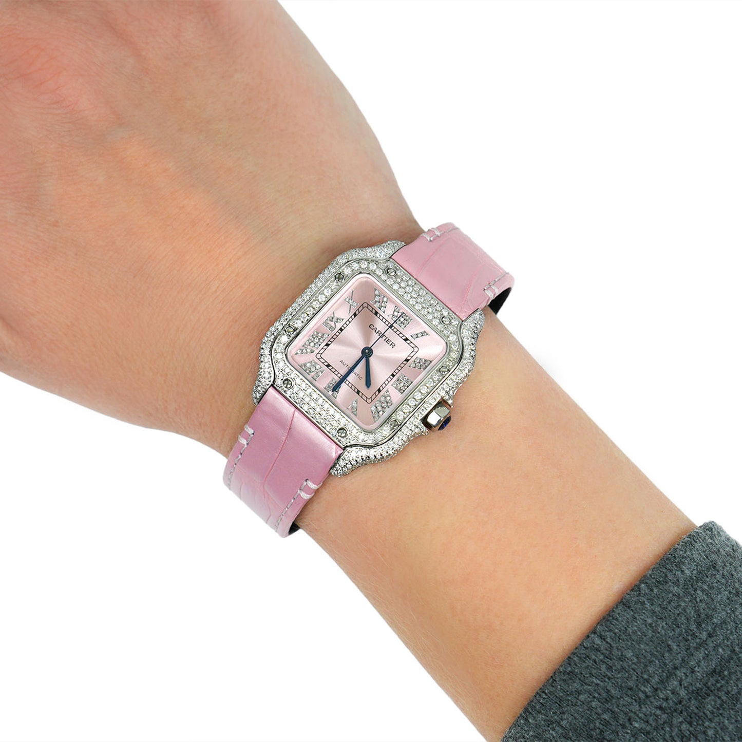 Pink watch with diamond accents on a wrist against a white background [lifestyle]