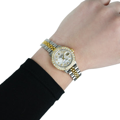 Gold and silver watch on a wrist with a white background [lifestyle]