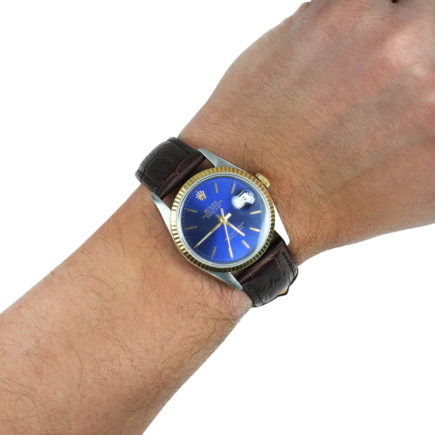 Wrist wearing a watch with a blue face and brown leather strap on a white background [lifestyle]