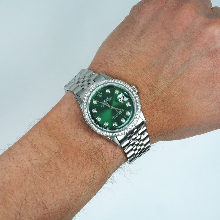 Green watch with silver bezel on a wrist against a light gray background [lifestyle]