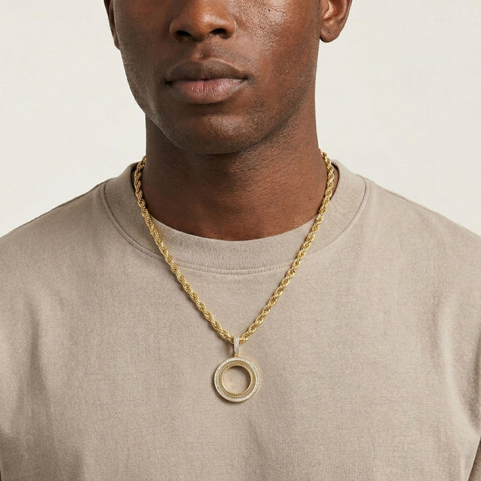 Man wearing a gold chain necklace with a pendant on a plain background [lifestyle]