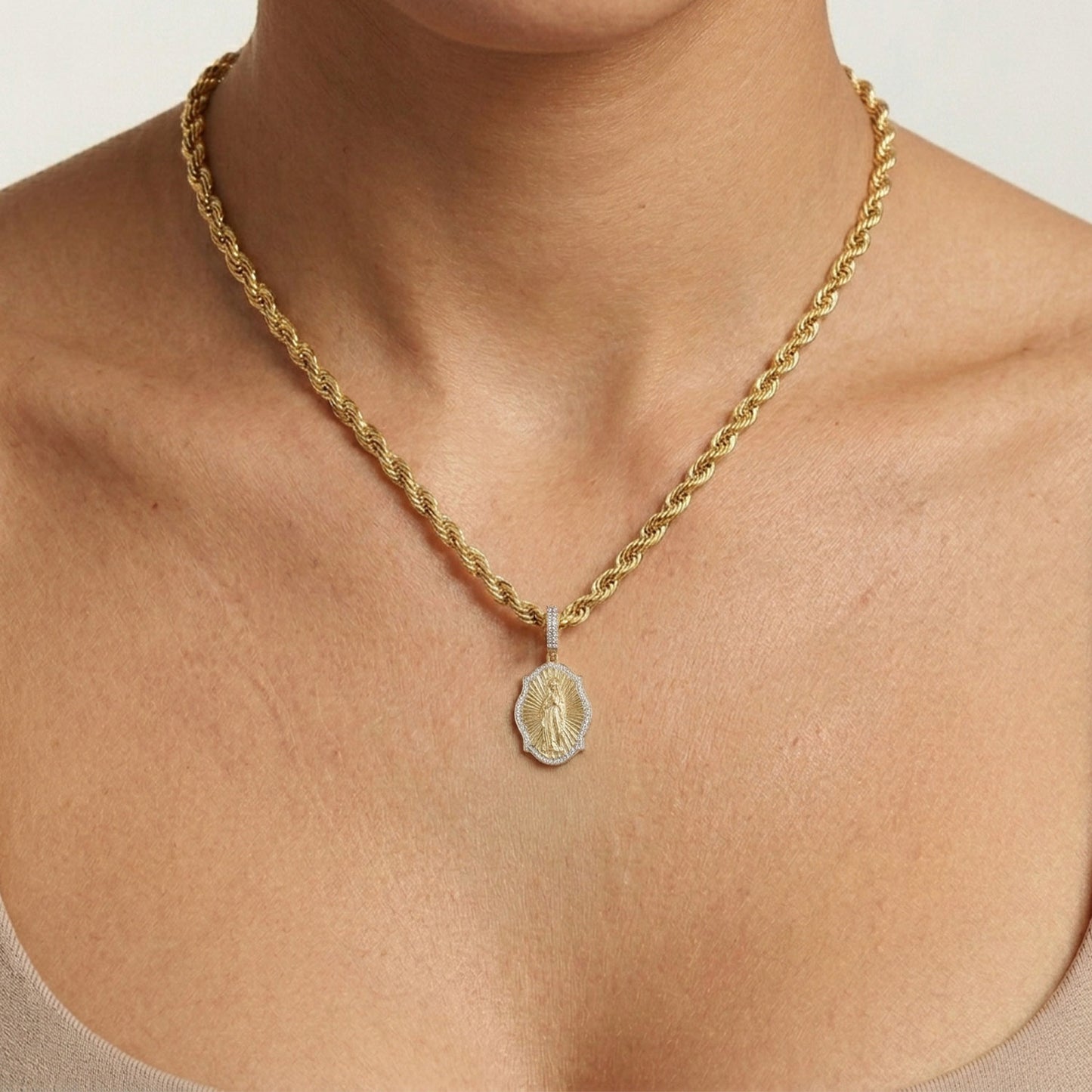 Gold necklace with a pendant on a person's neck against a neutral background [lifestyle]