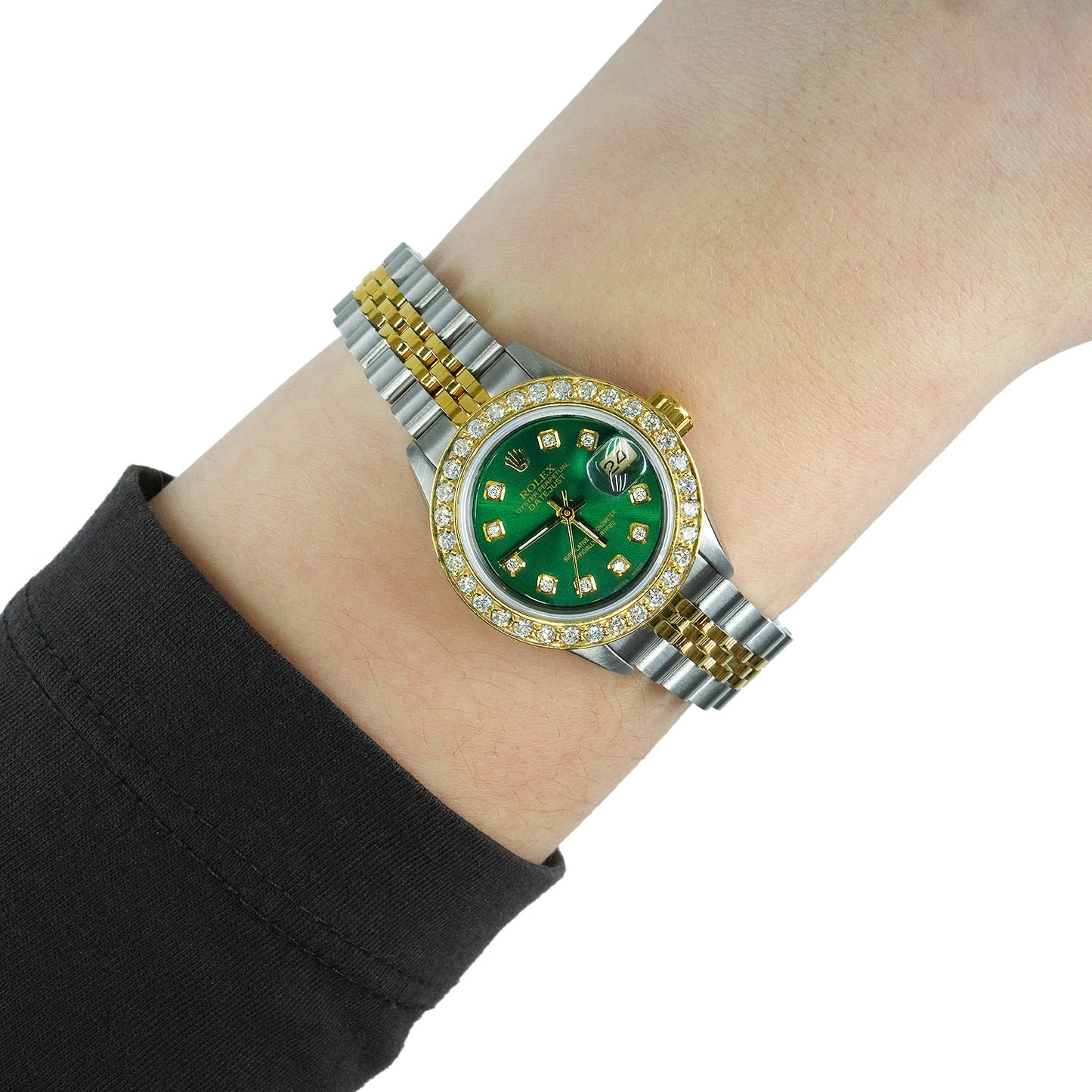 Two-tone watch with a green face on a wrist against a white background [lifestyle}