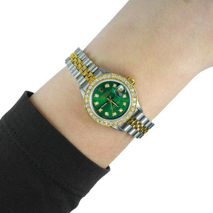 Two-tone watch with a green face on a wrist against a white background [lifestyle}