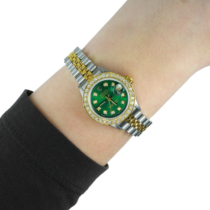 Two-tone watch with a green face on a wrist against a white background [lifestyle}