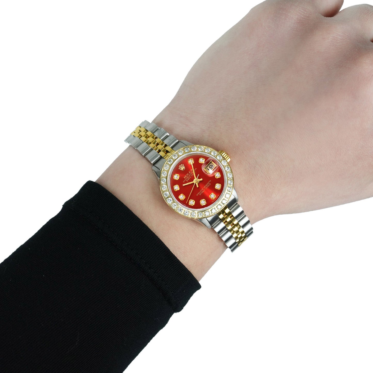Wrist wearing a watch with a red face and gold accents on a white background [lifestyle]