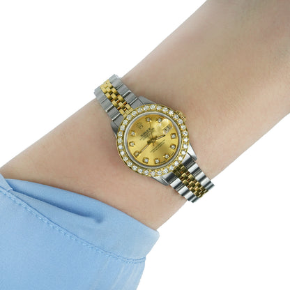 Gold and silver watch on a wrist with a light blue sleeve [lifestyle]