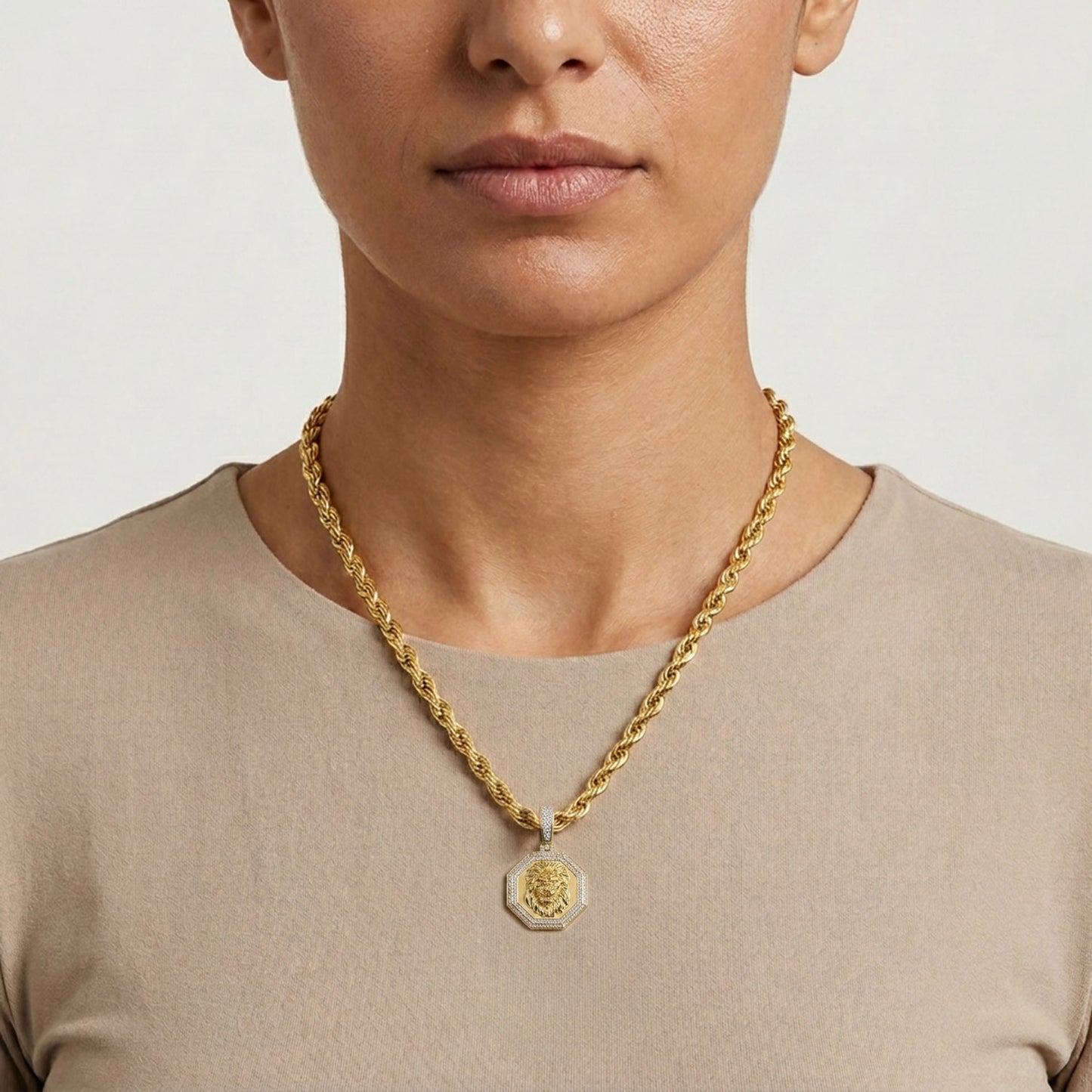 Person wearing a gold necklace with a pendant on a plain background [lifestyle]