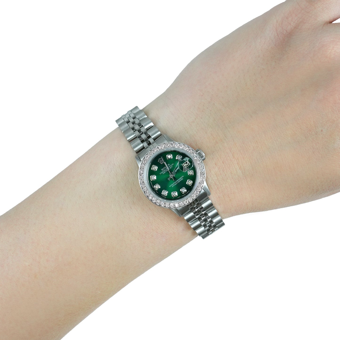 Silver watch with a green face on a wrist against a white background [lifestyle]