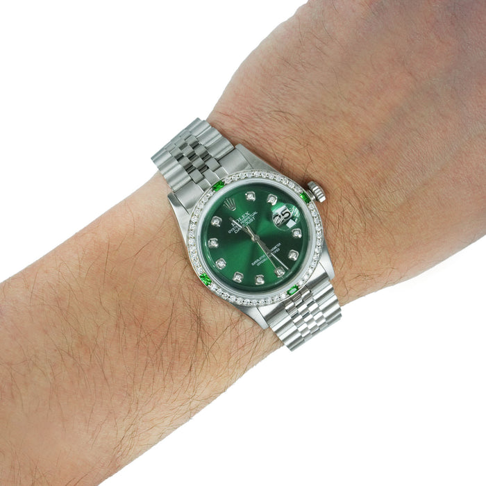 Silver watch with a green face on a wrist against a white background [lifestyle}