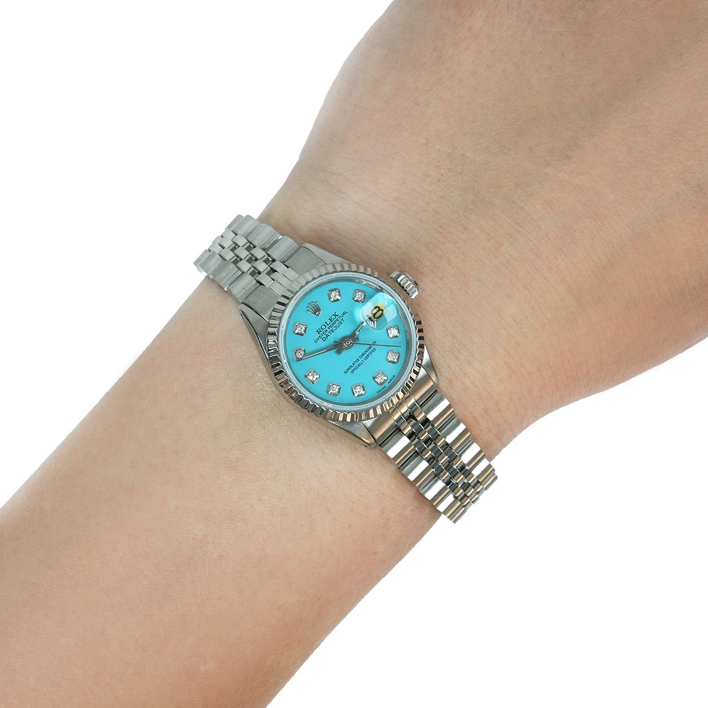 Silver watch with a blue face on a wrist against a white background [lifestyle]