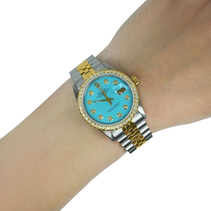 Luxury watch with turquoise dial and gold accents on a wrist against a white background [lifestyle]