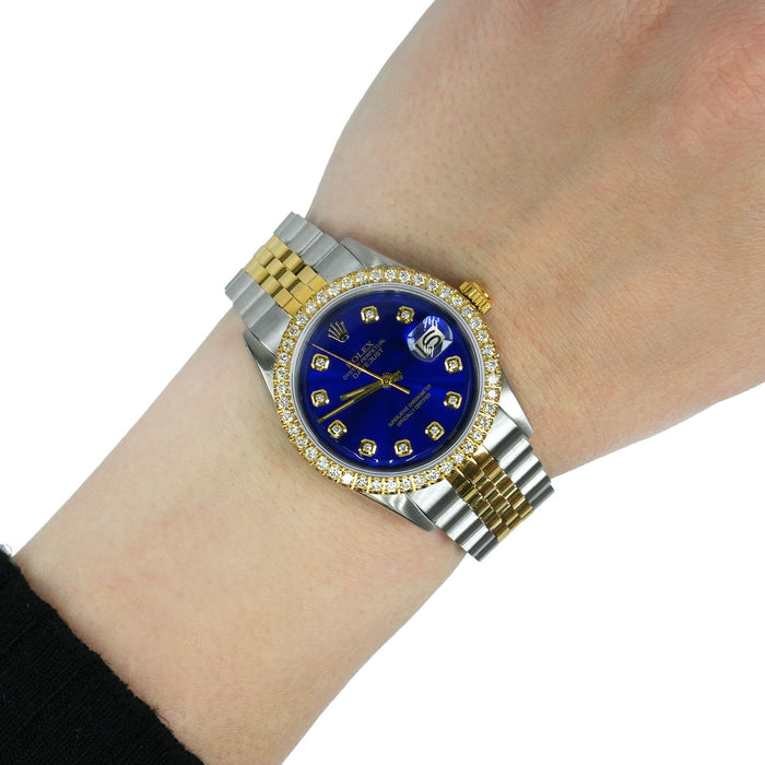 Luxury watch with blue dial and gold accents on a wrist against a white background [lifestyle]