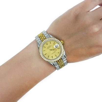 A two-tone Rolex Datejust watch with a yellow gold dial and bezel, paired with a silver and gold two-tone link bracelet, shown on a model's wrist against a white background. [lifestyle]