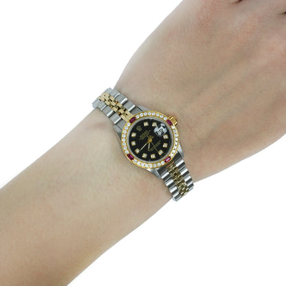 Wrist wearing a silver and gold watch with a black face on a white background [lifestyle]