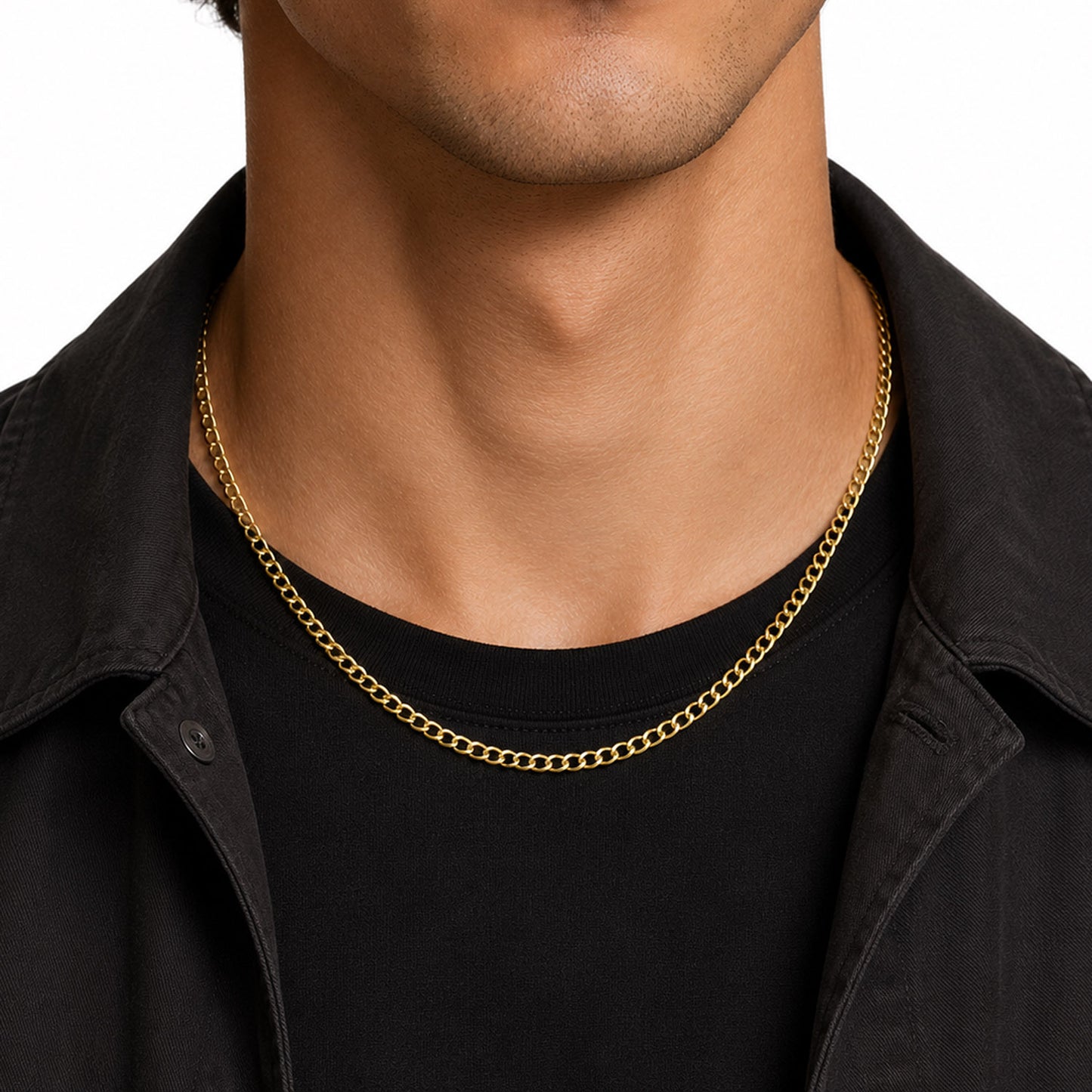 A close-up of a model's neck and lower face wearing a delicate gold chain necklace over a black t-shirt and black overshirt. [lifestyle]