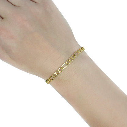 A delicate gold chain bracelet worn on a person's wrist, shown against a plain white background. [lifestyle]