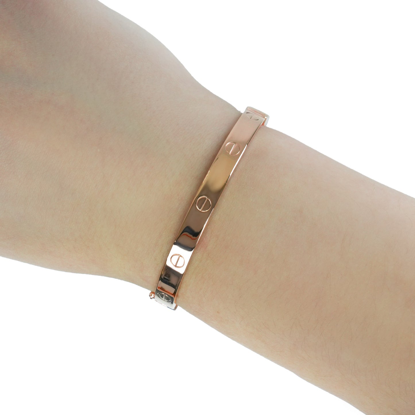 A slim rose gold bangle bracelet with engraved screw-head motifs, shown worn on a person's wrist against a white background. [lifestyle]