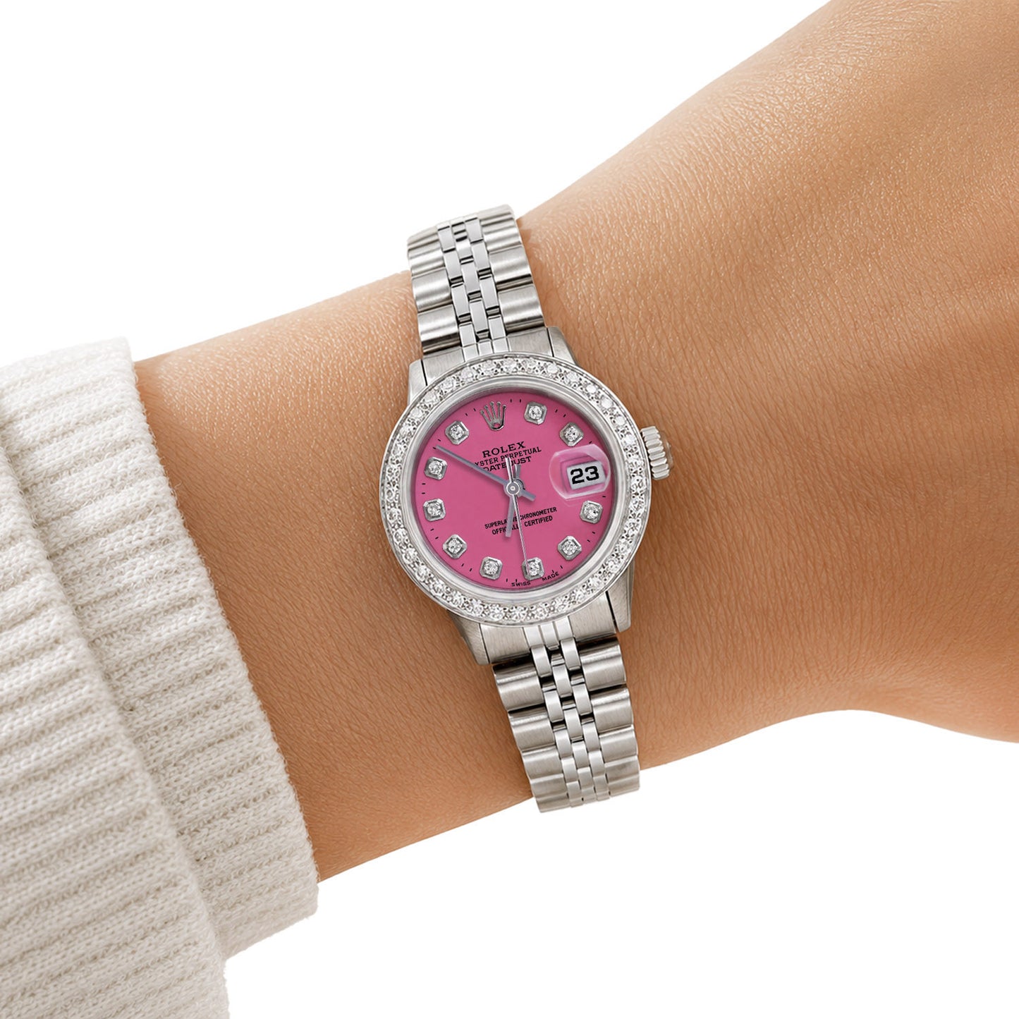A Rolex Lady Day watch with a pink dial and diamond-set bezel, shown worn on a person's wrist. [lifestyle]