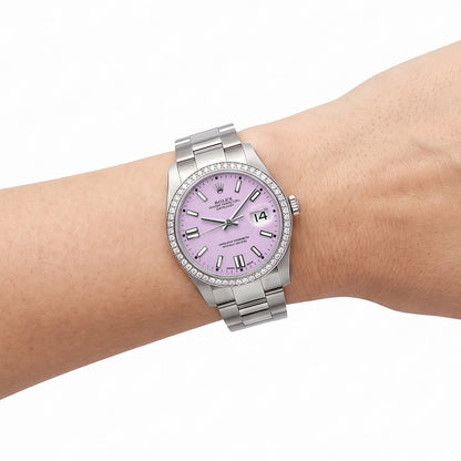 A Rolex Oyster Perpetual Datejust watch with a light purple dial and a silver stainless steel bracelet, shown worn on a person's wrist against a white background. [lifestyle]