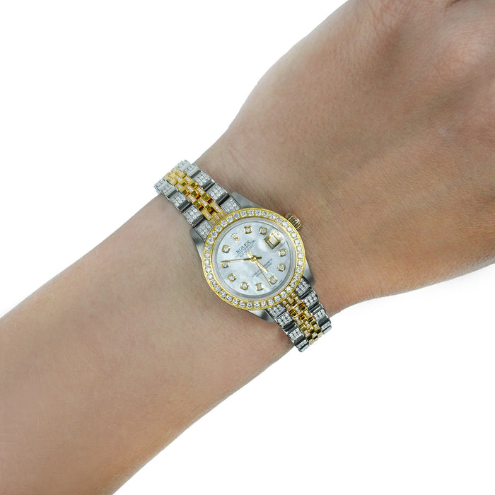 A two-tone stainless steel and yellow gold watch with a diamond bezel and matching link bracelet, shown worn on a person's wrist against a white background. [lifestyle]