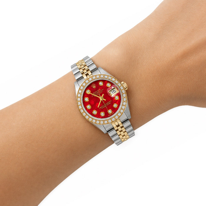A two-tone Rolex wristwatch with a red dial and diamond-set bezel, worn on a person's wrist against a clean white background. [lifestyle]